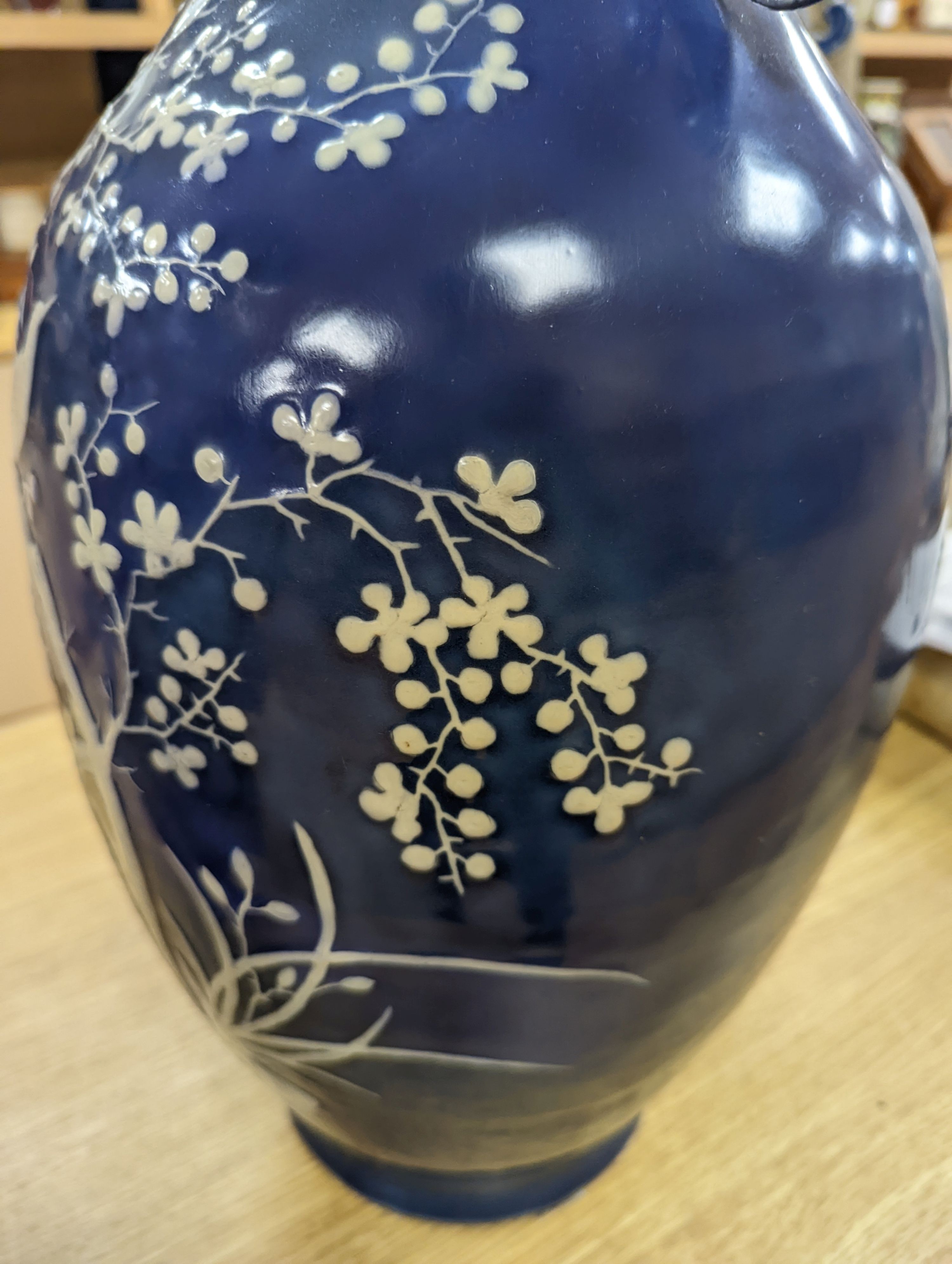 A pair of large 19th century Chinese slip decorated blue ground vases, restored, 59cm